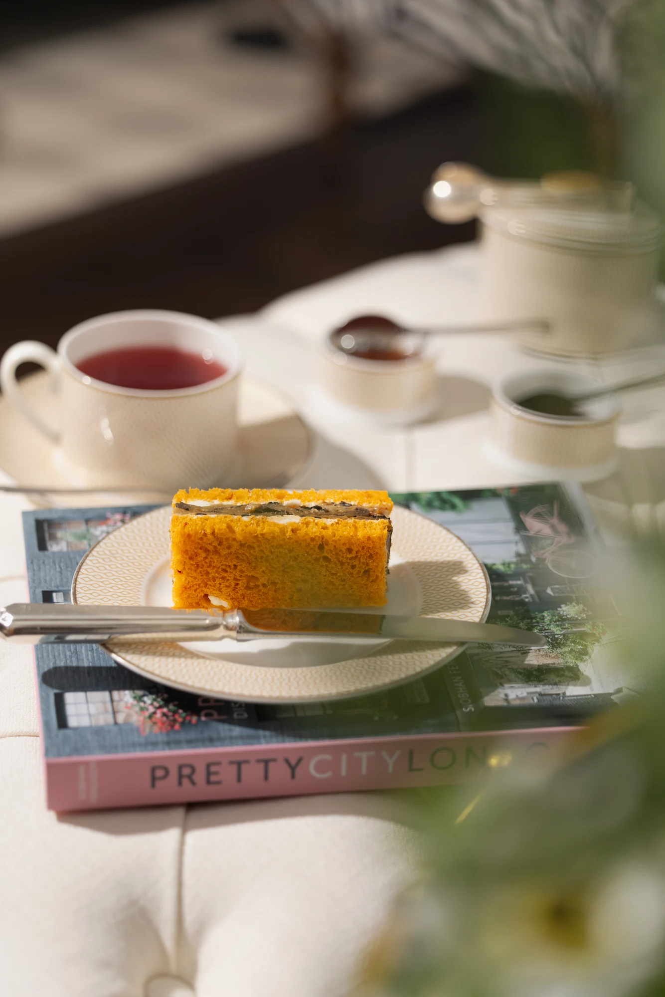 A plated dessert beside a cup of tea